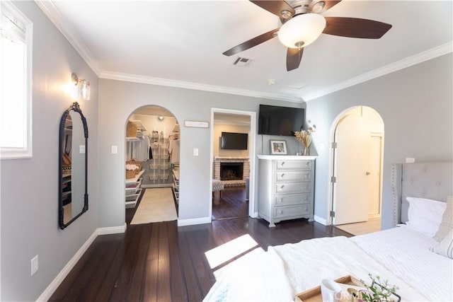 6903 E Driscoll St, Long Beach, CA 90815 - bedroom with arched walkways, hardwood / wood-style flooring, ornamental molding, a walk in closet, and ceiling fan