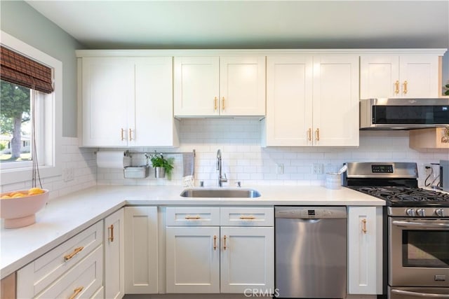 6903 E Driscoll St, Long Beach, CA 90815 - kitchen with appliances with stainless steel finishes, a sink, white cabinets, and light countertops