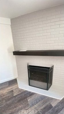 1741 Tustin Ave Unit 5, Costa Mesa, CA 92627 - detailed view of a brick fireplace, baseboards, and wood finished floors