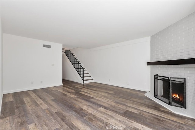 1741 Tustin Ave Unit 2A, Costa Mesa, CA 92627 - unfurnished living room with a fireplace, stairs, and wood finished floors