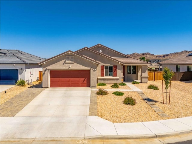 3615 Santa Monica Ct, Rosamond, CA 93560 - ranch-style house featuring concrete driveway, an attached garage, stucco siding, a tiled roof, and a mountain view