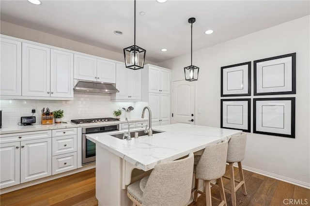 410 N Tapia Ln, Brea, CA 92821 - kitchen with appliances with stainless steel finishes, a sink, under cabinet range hood, white cabinetry, and an island with sink
