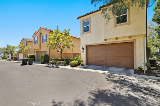410 N Tapia Ln, Brea, CA 92821 - mediterranean / spanish-style home with an attached garage, stucco siding, a tiled roof, and central AC unit