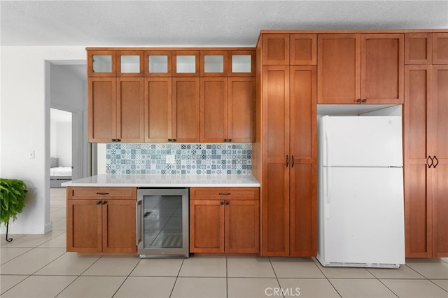 32955 Buckskin Rd, Temecula, CA 92592 - kitchen with freestanding refrigerator, wine cooler, light countertops, brown cabinetry, and a textured ceiling
