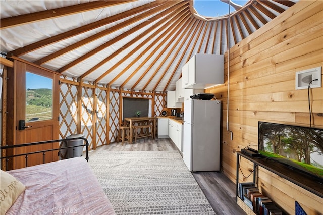 32955 Buckskin Rd, Temecula, CA 92592 - unfurnished bedroom featuring freestanding refrigerator, vaulted ceiling, wood walls, and wood finished floors