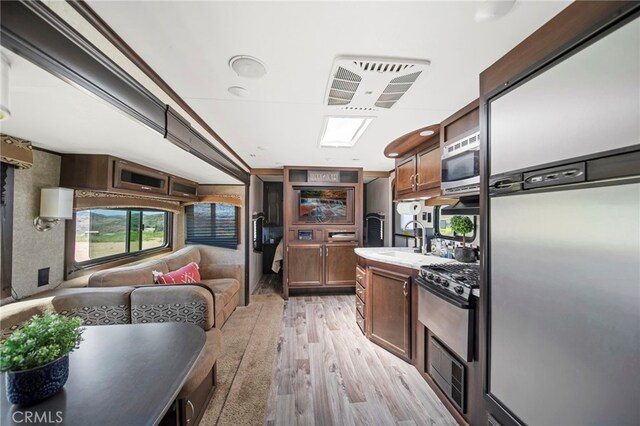 32955 Buckskin Rd, Temecula, CA 92592 - kitchen with appliances with stainless steel finishes, light wood-style floors, a sink, open floor plan, and light countertops