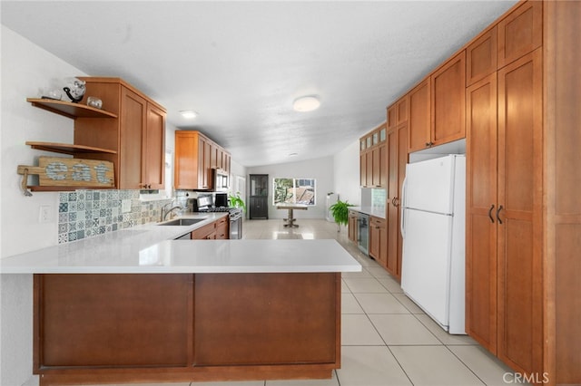 32955 Buckskin Rd, Temecula, CA 92592 - kitchen featuring freestanding refrigerator, stainless steel range with gas stovetop, open shelves, light countertops, and brown cabinetry