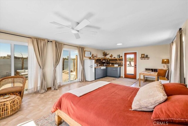 68365 Emerald Dr Unit 29, Palms, CA 92277 - bedroom featuring access to exterior, multiple windows, and freestanding refrigerator