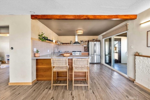 68365 Emerald Dr Unit 29, Palms, CA 92277 - kitchen featuring freestanding refrigerator, beam ceiling, wood finished floors, open shelves, and a peninsula