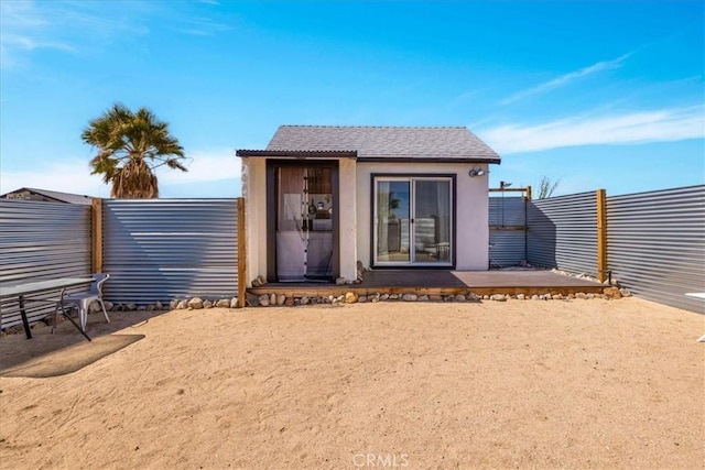 68365 Emerald Dr Unit 29, Palms, CA 92277 - rear view of property with a fenced backyard, an outdoor structure, and stucco siding