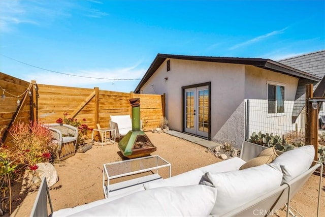68365 Emerald Dr Unit 29, Palms, CA 92277 - rear view of property featuring french doors, an outdoor living space with a fire pit, stucco siding, and a patio area