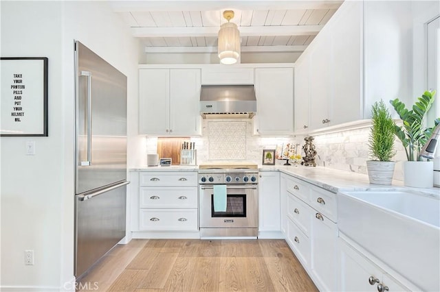 802 Rembrandt Dr, Laguna Beach, CA 92651 - kitchen with wall chimney exhaust hood, high quality appliances, backsplash, white cabinets, and wooden ceiling with exposed beams