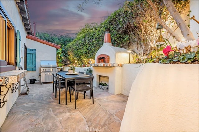 802 Rembrandt Dr, Laguna Beach, CA 92651 - patio terrace at dusk with a fireplace, a patio, area for grilling, and outdoor dining area