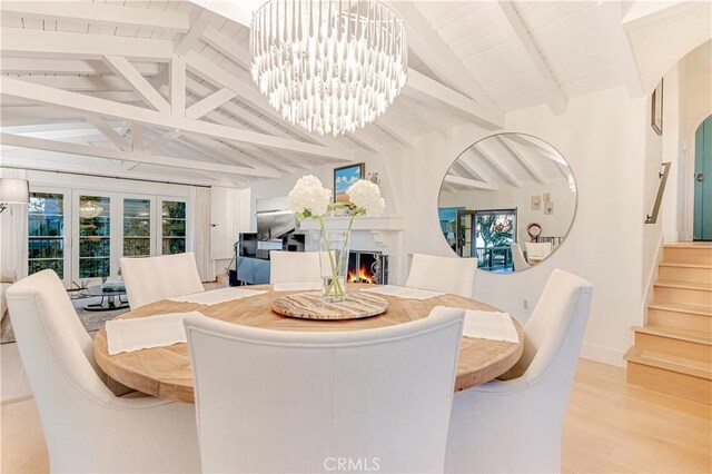802 Rembrandt Dr, Laguna Beach, CA 92651 - dining space featuring stairs, a warm lit fireplace, wood finished floors, a chandelier, and baseboards
