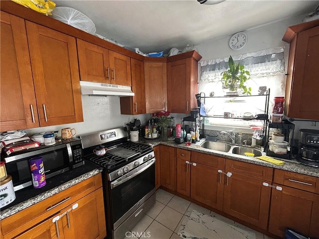 1212 E 54th St, Los Angeles, CA 90011 - kitchen with appliances with stainless steel finishes, under cabinet range hood, a sink, brown cabinets, and dark stone countertops