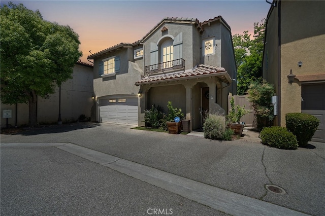 16741 Tim Ln, Van Nuys, CA 91406 - mediterranean / spanish home featuring a tile roof, a garage, stucco siding, driveway, and a balcony