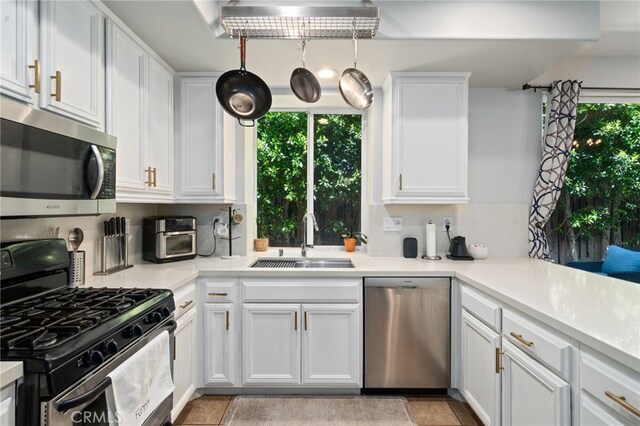 16741 Tim Ln, Van Nuys, CA 91406 - kitchen featuring stainless steel appliances, a sink, white cabinets, and light countertops