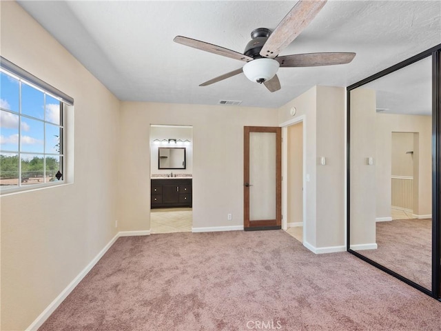 17970 Pitache St, Hesperia, CA 92345 - unfurnished bedroom featuring light carpet, baseboards, connected bathroom, and a ceiling fan