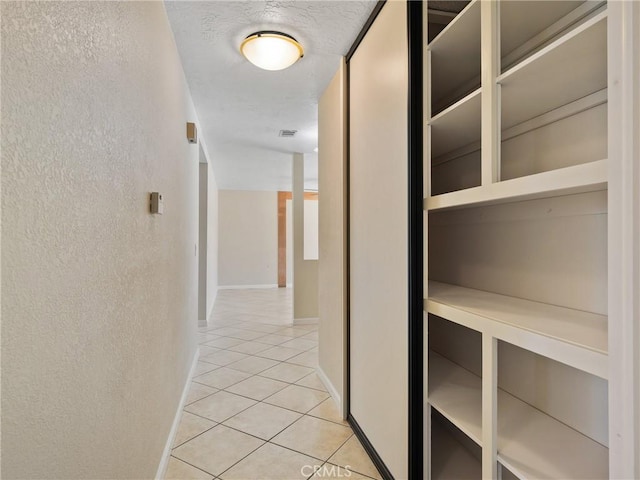 17970 Pitache St, Hesperia, CA 92345 - hall with light tile patterned floors, a textured wall, and baseboards