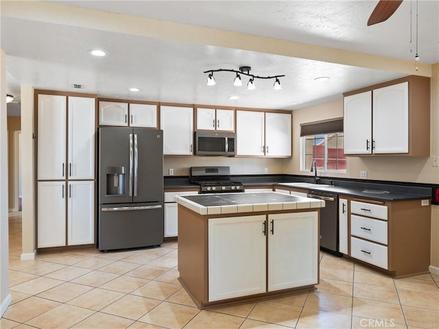 17970 Pitache St, Hesperia, CA 92345 - kitchen with stainless steel appliances, white cabinets, a kitchen island, tile counters, and light tile patterned floors