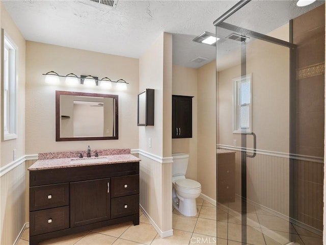 17970 Pitache St, Hesperia, CA 92345 - full bathroom with vanity, wainscoting, a shower stall, tile patterned flooring, and toilet