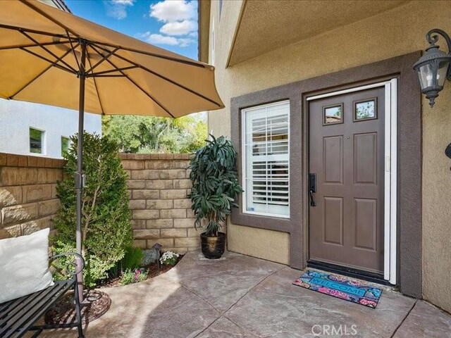 27718 Heartwood Ct, Valencia, CA 91354 - view of exterior entry featuring a patio area and stucco siding