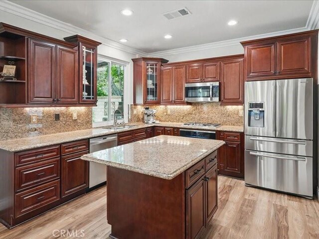 27718 Heartwood Ct, Valencia, CA 91354 - kitchen with appliances with stainless steel finishes, a sink, light wood-style floors, ornamental molding, and light stone counters