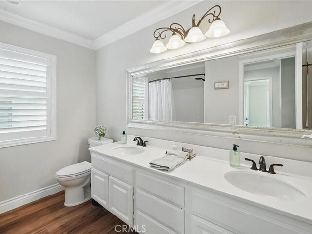 27718 Heartwood Ct, Valencia, CA 91354 - full bath with crown molding, toilet, wood finished floors, baseboards, and double vanity