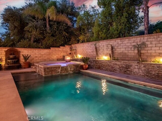 27718 Heartwood Ct, Valencia, CA 91354 - pool at dusk featuring a fenced backyard and a pool with connected hot tub