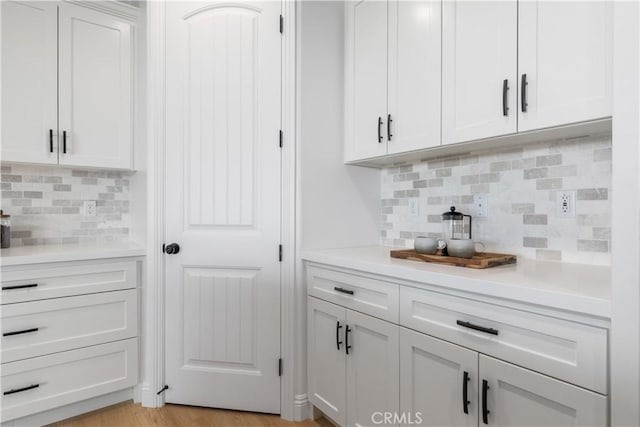 13165 N Bluffs Ct, San Miguel, CA 93451 - kitchen with decorative backsplash, light countertops, white cabinetry, and light wood-style flooring