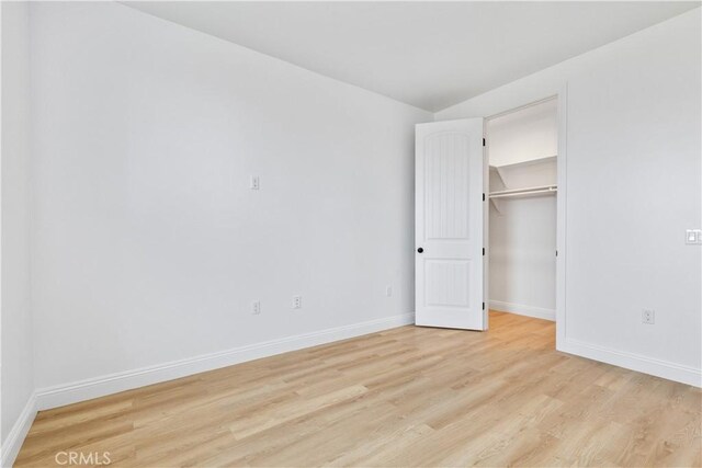 13165 N Bluffs Ct, San Miguel, CA 93451 - unfurnished bedroom with light wood-type flooring, baseboards, and a walk in closet