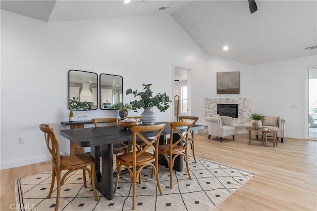 13165 N Bluffs Ct, San Miguel, CA 93451 - dining room with a tiled fireplace, light wood finished floors, high vaulted ceiling, recessed lighting, and baseboards