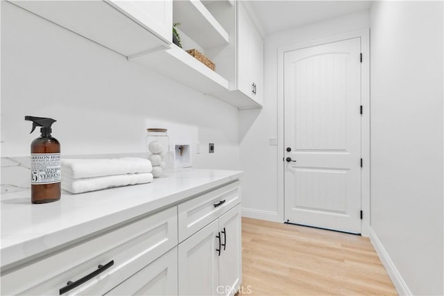 13165 N Bluffs Ct, San Miguel, CA 93451 - laundry area with cabinet space, electric dryer hookup, light wood-type flooring, and baseboards