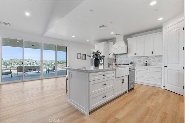 13165 N Bluffs Ct, San Miguel, CA 93451 - kitchen with custom range hood, tasteful backsplash, light wood-style floors, white cabinetry, and recessed lighting