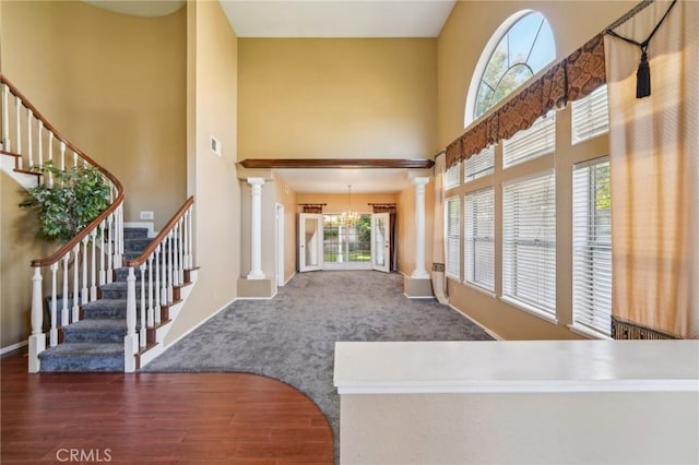 12958 Boston Ave, Chino, CA 91710 - carpeted foyer entrance featuring ornate columns, a high ceiling, stairs, wood finished floors, and baseboards