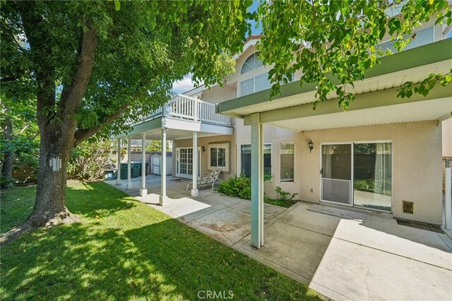 12958 Boston Ave, Chino, CA 91710 - rear view of house featuring stucco siding, a lawn, a patio, and a balcony