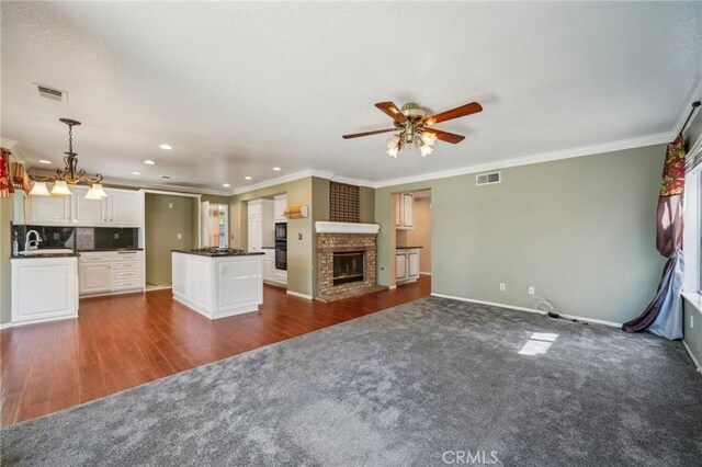 12958 Boston Ave, Chino, CA 91710 - unfurnished living room with a ceiling fan, dark carpet, crown molding, recessed lighting, and baseboards