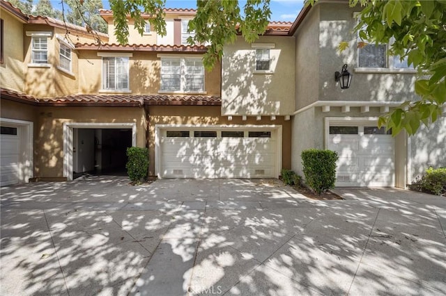 23423 Abbey Glen Pl Unit 30, Valencia, CA 91354 - view of front of property featuring driveway, a garage, stucco siding, and a tile roof