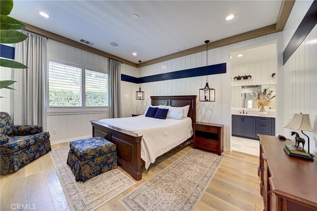 39454 Chamise St, Temecula, CA 92591 - bedroom featuring light wood-style flooring, connected bathroom, a sink, recessed lighting, and a decorative wall