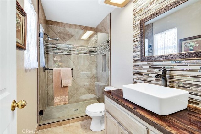 57490 Redondo St, Yucca Valley, CA 92284 - bathroom featuring toilet, a stall shower, vanity, backsplash, and tile patterned flooring