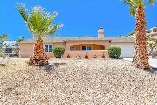 57490 Redondo St, Yucca Valley, CA 92284 - ranch-style home featuring a garage, a chimney, stucco siding, and driveway