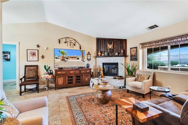 57490 Redondo St, Yucca Valley, CA 92284 - living room with lofted ceiling, a brick fireplace, light tile patterned floors, and baseboards