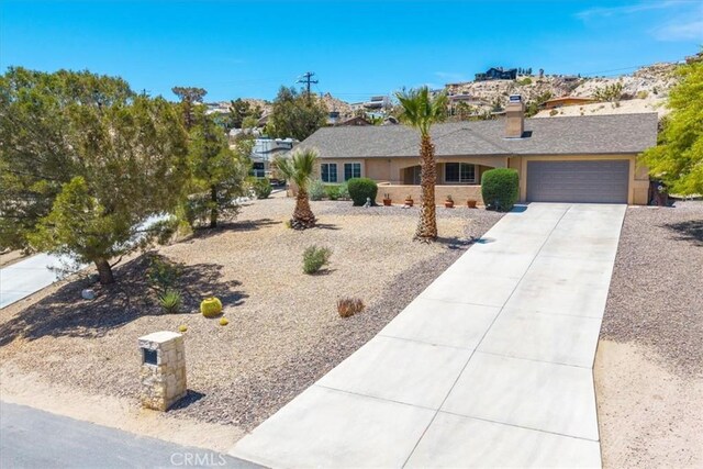 57490 Redondo St, Yucca Valley, CA 92284 - ranch-style home featuring a garage, driveway, and a chimney