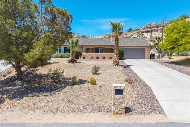 57490 Redondo St, Yucca Valley, CA 92284 - ranch-style home featuring an attached garage, driveway, and stucco siding