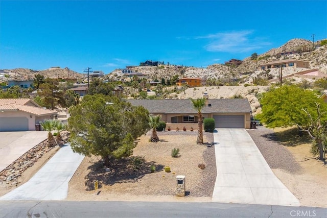 57490 Redondo St, Yucca Valley, CA 92284 - ranch-style house featuring concrete driveway, a residential view, and an attached garage
