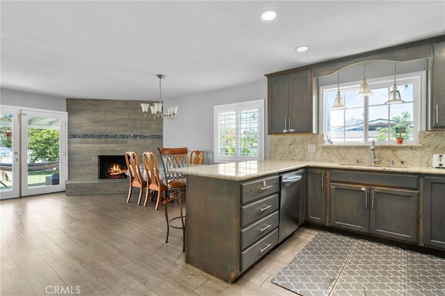 5979 Stanton Ave, Highland, CA 92346 - kitchen with dishwasher, a sink, a peninsula, a chandelier, and light wood-style floors