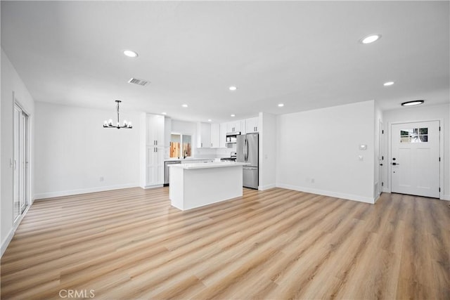 1608 Heron Ct, Redlands, CA 92374 - unfurnished living room featuring a chandelier, recessed lighting, light wood-style flooring, and baseboards