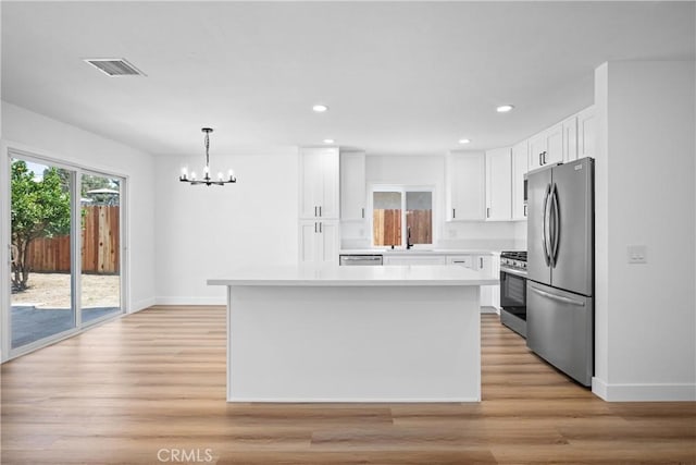 1608 Heron Ct, Redlands, CA 92374 - kitchen featuring appliances with stainless steel finishes, a sink, a chandelier, white cabinets, and light countertops