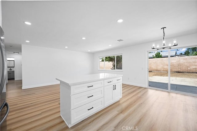 1608 Heron Ct, Redlands, CA 92374 - kitchen featuring light wood-type flooring, a chandelier, baseboards, white cabinets, and recessed lighting