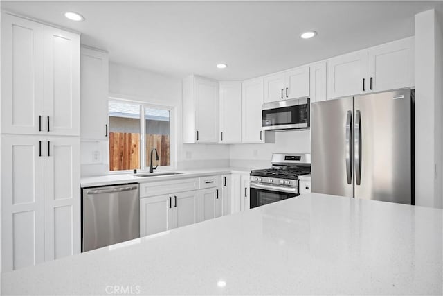 1608 Heron Ct, Redlands, CA 92374 - kitchen featuring stainless steel appliances, a sink, white cabinets, light stone countertops, and recessed lighting